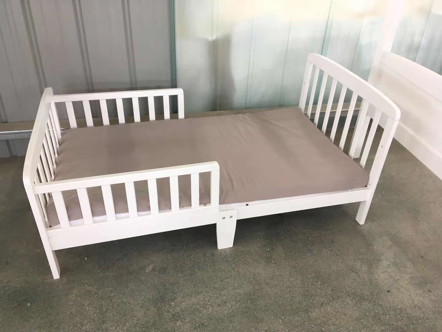 white wooden toddler bed and mattress